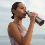 Mujer bebiendo agua al aire libre